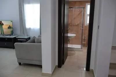 a living room with a couch and a sink and a bathroom at Specious 2BR VILLA WITH MAIDROOM AND HUGE GARDEN IN JVT DUBAI in Dubai