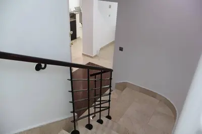 a spiral staircase with a metal railing in a house at Specious 2BR VILLA WITH MAIDROOM AND HUGE GARDEN IN JVT DUBAI in Dubai