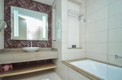 a bathroom with a sink and a tub and a mirror at DAMAC Towers by Paramount Hotels & Resorts Dubai in Dubai
