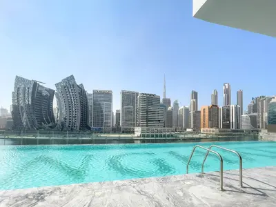 a swimming pool with a city skyline in the background at Elegant 1-Bedroom Apartment in Dubai