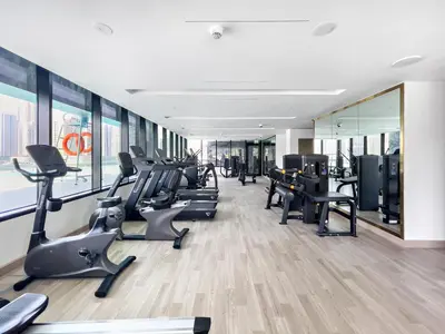 a gym with treadmills and ellipticals in a building at Elegant 1-Bedroom Apartment in Dubai