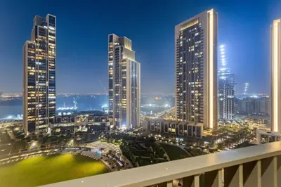 a view of a city at night with tall buildings at Chic 2BR Stay at Creek Horizon with Pool, Gym and Prime Dubai Location in Dubai