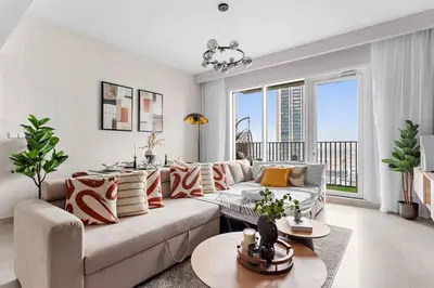a living room with a couch and a large window at Chic 2BR Stay at Creek Horizon with Pool, Gym and Prime Dubai Location in Dubai