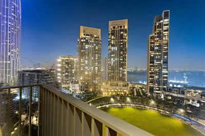 a view of a city skyline at night at Chic 2BR Stay at Creek Horizon with Pool, Gym and Prime Dubai Location in Dubai