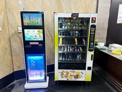 a drink vending machine with a cell phone next to it at The Hive Partition Room in Tecom Near Metro in Dubai