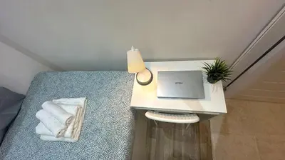 a desk with a laptop on top of a bed at The Hive Partition Room in Tecom Near Metro in Dubai