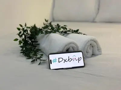 a sign sitting on a bed with a plant at Vista Partition Room in Tecom Near Internet City Metro in Dubai