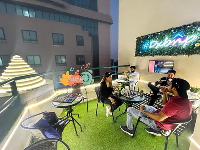 a group of people sitting at tables on a balcony at Cove Partition Room in Tecom Near Internet City Metro in Dubai