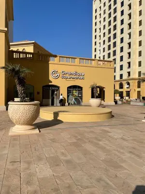 a building with two large vases in a courtyard at Luxury Studio in Murjan 2, JBR in Dubai