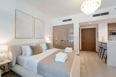 a bedroom with a large bed and a kitchen at Urban Oasis by Missoni Studio in Dubai