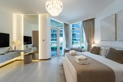 a bedroom with a large bed and a living room at Urban Oasis by Missoni Studio in Dubai