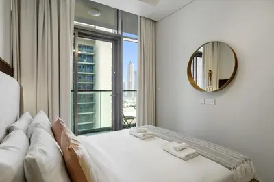 a bedroom with a bed with a mirror and a window at Stylish 1-Bedroom in Prime Business Bay Aykon C in Dubai