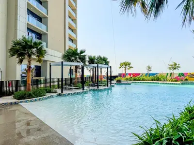 a swimming pool in front of a building with palm trees at Stylish 1-Bedroom in Prime Business Bay Aykon C in Dubai