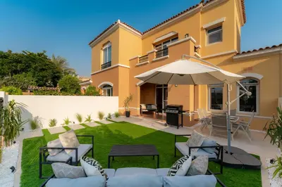 a villa with a patio and an umbrella at Luxury Villa in Ranches 1, on Pool and Park in Dubai