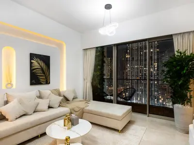 a living room with a couch and a large window at SmartStay at Grande Signature - Downtown Dubai City Views - Brand New Luxury Apartments in Dubai