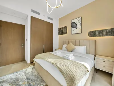 a bedroom with a large bed and a chandelier at SmartStay at Grande Signature - Downtown Dubai City Views - Brand New Luxury Apartments in Dubai