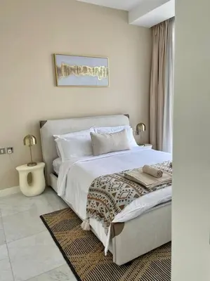 a bedroom with a large bed with white sheets and pillows at 1BDR-furnished apartment, Business Bay, CANAL VIEW in Dubai