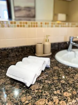a bathroom with a sink and towels on a counter at Naseem - Elegant Coastal Retreat with Stunning Marina Views in Dubai