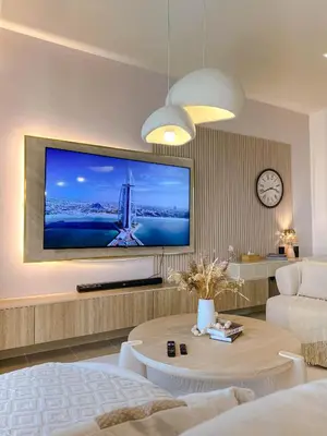 a living room with a large flat screen tv on the wall at Naseem - Elegant Coastal Retreat with Stunning Marina Views in Dubai