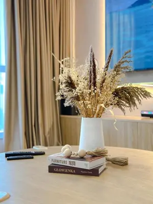 a table with a book and a vase of flowers at Naseem - Elegant Coastal Retreat with Stunning Marina Views in Dubai