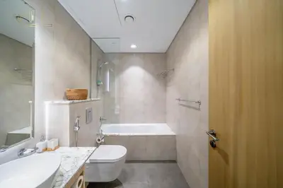 a bathroom with a tub and a toilet and a sink at Luxury 2-Bed in Paramount Midtown Hotel Full Burj Khalifa Views 64th Floor Pool & Burj Views in Dubai