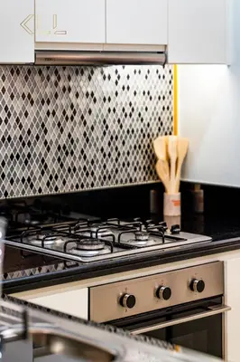 a stove top in a kitchen with a tile wall at Luxury 2-Bed in Paramount Midtown Hotel Full Burj Khalifa Views 64th Floor Pool & Burj Views in Dubai