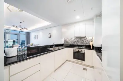 a kitchen with white cabinets and a sink at Luxury 2-Bed in Paramount Midtown Hotel Full Burj Khalifa Views 64th Floor Pool & Burj Views in Dubai