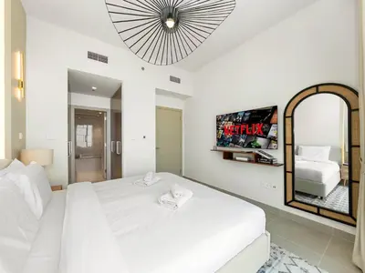 a bedroom with a white bed and a mirror at Brand New Downtown unit! Bvlgari World Island View in Dubai