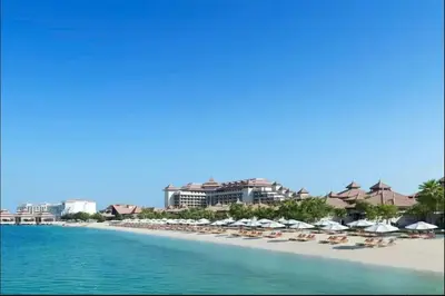 a beach with chairs and umbrellas and the ocean at AWS Holiday Homes - Tranquil Stay at the Palm in Dubai