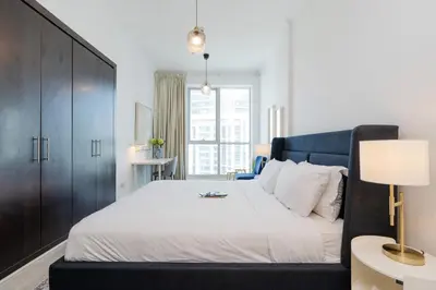 a bedroom with a large bed with a black headboard at Stunning Interior in an deal Location in Dubai