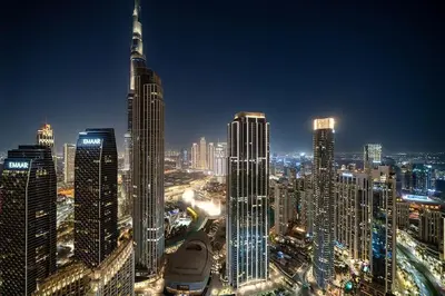 a night view of a city with tall buildings at Casa Nomad - Full Burj Khalifa & Fountain View at Luxury 4 Bed in Dubai