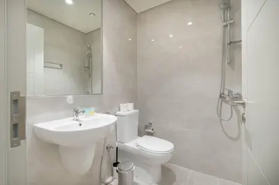 a bathroom with a toilet and a sink and a shower at Casa Nomad - Full Burj Khalifa & Fountain View at Luxury 4 Bed in Dubai