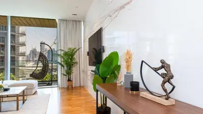 a living room with a table with a statue at Bluewaters Island - Luxury 2BR with Ain View by TLRE Holiday Homes in Dubai