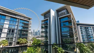 a view of the london eye from a balcony of a building with palm trees at Bluewaters Island - Luxury 2BR with Ain View by TLRE Holiday Homes in Dubai