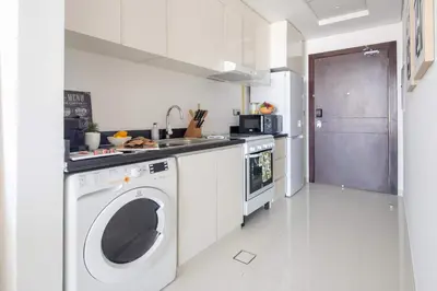 a kitchen with a washing machine and a sink at Frank Porter - Damac Ghalia in Dubai