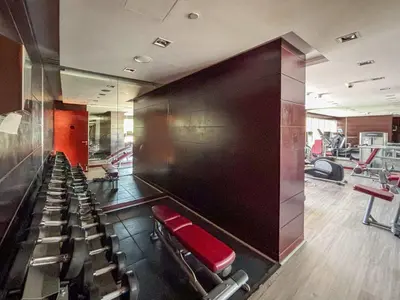 a gym with a red bench and chairs in it at Frank Porter - Damac Ghalia in Dubai