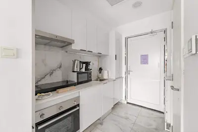 a kitchen with white cabinets and a door leading to a doorway at Silkhaus Ocean View in Palm Views Holiday Vibes in Dubai