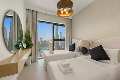 a hotel room with two beds and a large window at 4BR with Spacious Balcony & Stunning Burj Khalifa Views in Dubai