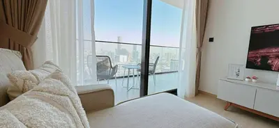 a bedroom with a bed and a large window with a view at Modern 1br In Jvc Balcony, Pool & Free Parking in Dubai