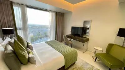 a hotel room with a bed and a large window at Appartement spacieux de luxe à 5mn du Burj Khalifa in Dubai