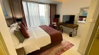 a hotel room with a bed and a desk and a television at Appartement spacieux de luxe à 5mn du Burj Khalifa in Dubai