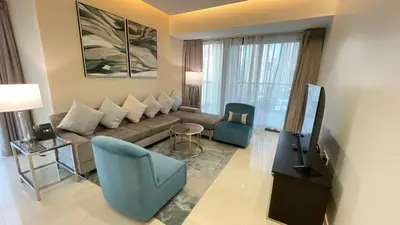 a living room with a couch and chairs and a tv at Appartement spacieux de luxe à 5mn du Burj Khalifa in Dubai