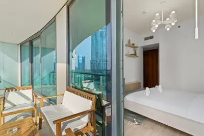 a bedroom with a balcony with a bed and chairs at Bright One BDR close to Burj Khalifa & Dubai Mall in Dubai