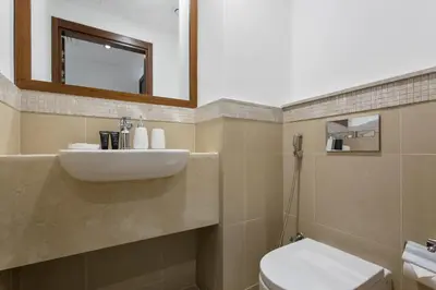 a bathroom with a sink and a toilet and a mirror at Bright One BDR close to Burj Khalifa & Dubai Mall in Dubai
