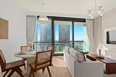 a living room with a table and chairs and a large window at Bright One BDR close to Burj Khalifa & Dubai Mall in Dubai