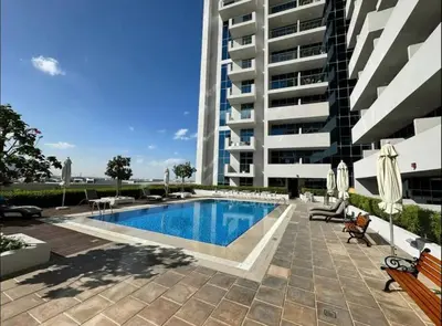 a swimming pool in front of a building at Studio - Azizi Riviera 37 in Dubai