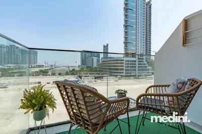two chairs on a balcony with a view of a city at Studio - Azizi Riviera 37 in Dubai