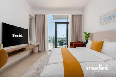 a hotel room with a bed and a television at Studio - Azizi Riviera 37 in Dubai