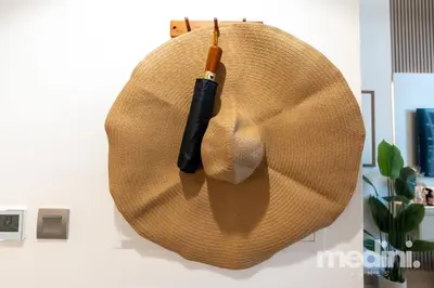 a straw hat with an umbrella hanging on a wall at 12min from Burj Khalifa - Studio - Azizi Riviera in Dubai