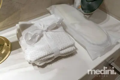 a pile of towels with a bow on a counter at 12min from Burj Khalifa - Studio - Azizi Riviera in Dubai